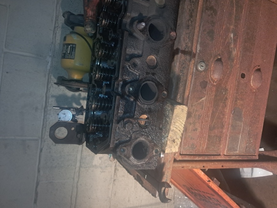 Engine cylinder head with valvetrain components on a workbench during engine overhaul